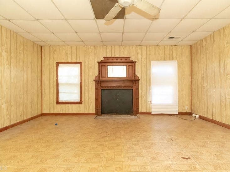 a shot of an empty room with a blocked out fireplace and yellow walls