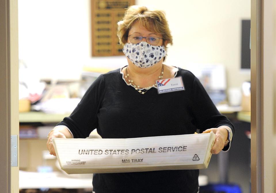 Town Clerk Terri Bunce carries out another box of ballots at Dennis Town Hall in this 2020 file photo.