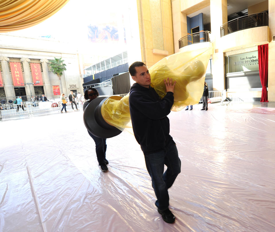 HOLLYWOOD, CA - FEBRUARY 22: Crew members carry a Oscar Statue for the red carpet for the 84th Annual Academy Awards at Hollywood and Highland on February 22, 2012 in Hollywood, California. (Photo by Michael Buckner/Getty Images)