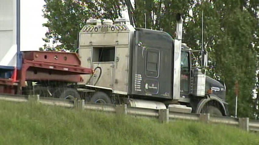 An oversize blue steel trailer on a semi-truck was carrying drilling equipment when it slammed into several trusses of the I-5 Skagit River overpass.