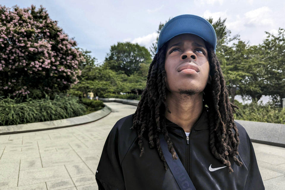 Zahir Harris, an 18-year-old incoming college freshman, looks up at the Martin Luther King Jr. memorial in Washington on Aug. 11, 2023. Harris remembers hearing King’s “I have a dream speech” in middle school. The movement behind that march, he said, is unfinished but he can see its successes in his own life as he walks around freely, eats where he wants, and chooses a college freely. Minorities did not have that advantage during King's time, he said. (AP Photo/Nathan Ellgren)