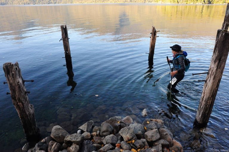 Una corredora que participa en los 110 kilómetros, en la orilla del Lago Lacar, en el kilómetro 68 luego de pasar el puesto de asistencia en la Estancia Quechuquina