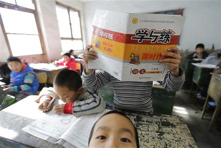 A student reads in class at Pengying School on the outskirts of Beijing November 11, 2013. REUTERS/Jason Lee