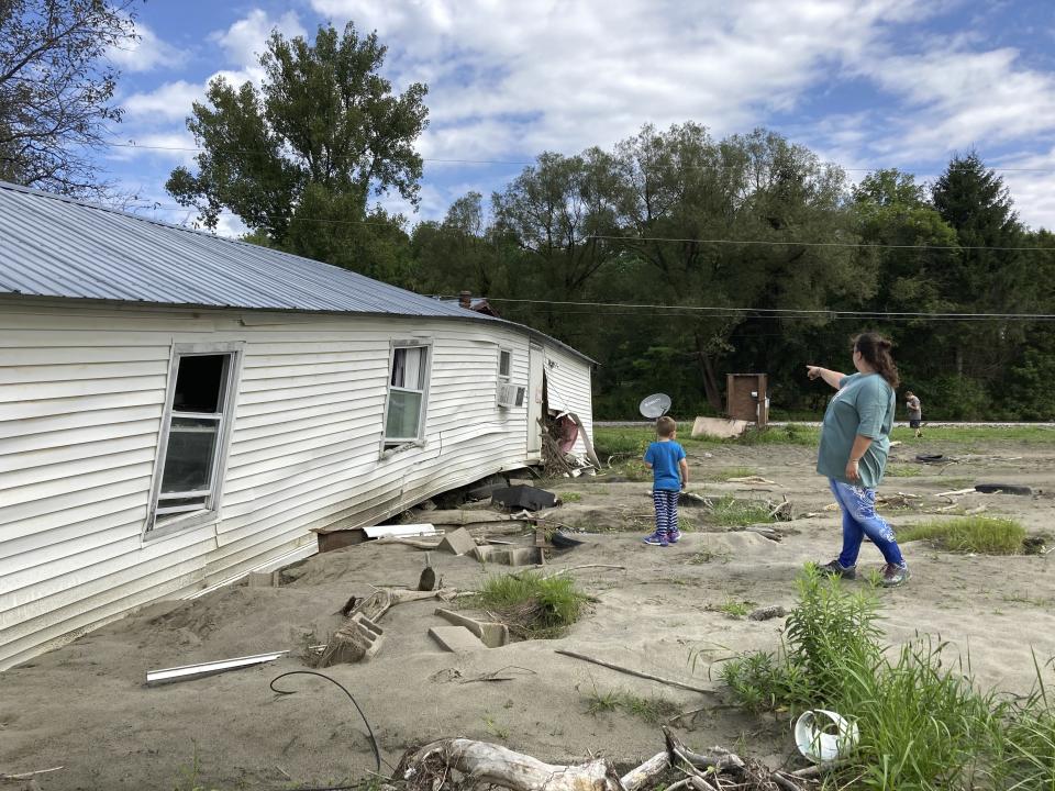 Sara Morris and her son visit their flood-ravaged home in Berlin, Vt.,on Tuesday, Aug. 29, 2023. With Vermont’s already tight housing market and cold weather fast approaching, some flood victims who lost homes don’t yet know where they’ll live. (AP Photo/Lisa Rathke)