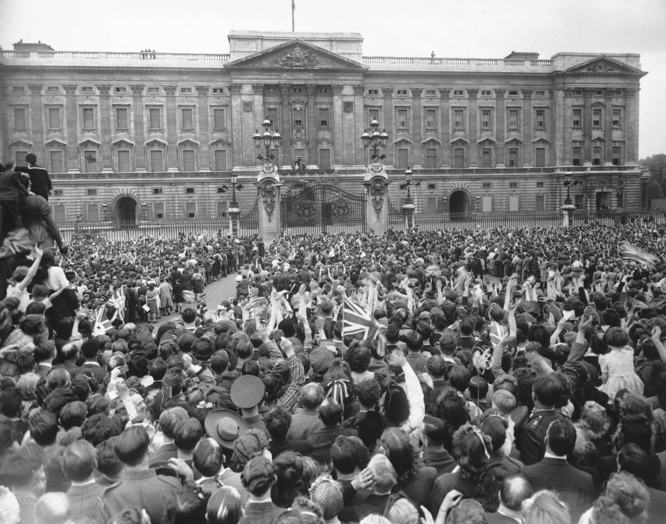 (Original Caption) V.E. Day In London. The crowd gathered outside Buckingham Palace, cheer and wave as their Majesties the King and Queen with the Princesses Elizabeth and Margaret Rose, appear on the balcony. 8th May 1945. (Photo by © Hulton-Deutsch Collection/CORBIS/Corbis via Getty Images)