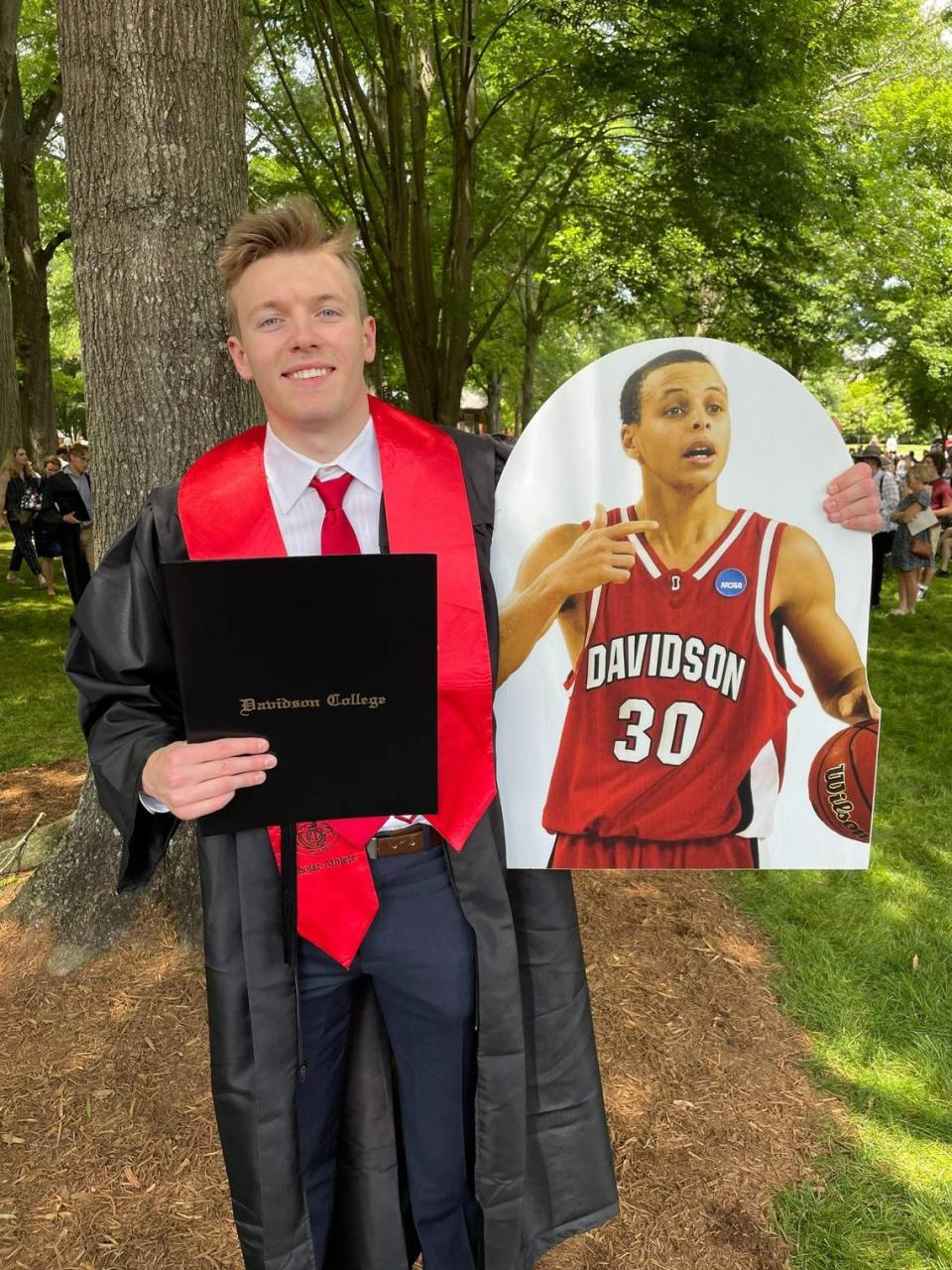 Davidson basketball player Michael Jones, who just finished his career, was part of the school’s Class of 2022. So was Stephen Curry (represented by cutout), who left Davidson in 2009 but has finished his degree, 13 years later.