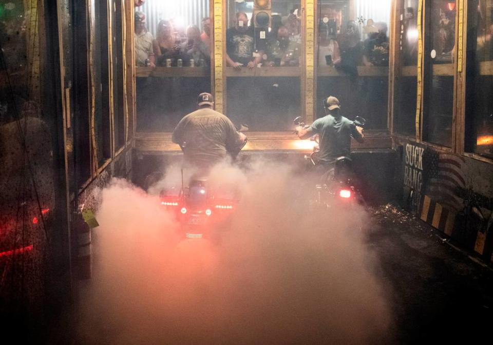 Bikers compete in the burnout pit at Suck Bang Blow bar in Murrells Inlet, S.C. during the 2024 Myrtle Beach Spring Rally. Their spinning tires burn rubber often shredding tires and filling the air with smoke, the roar of engines and the cheers from the crowd. May 16, 2024.