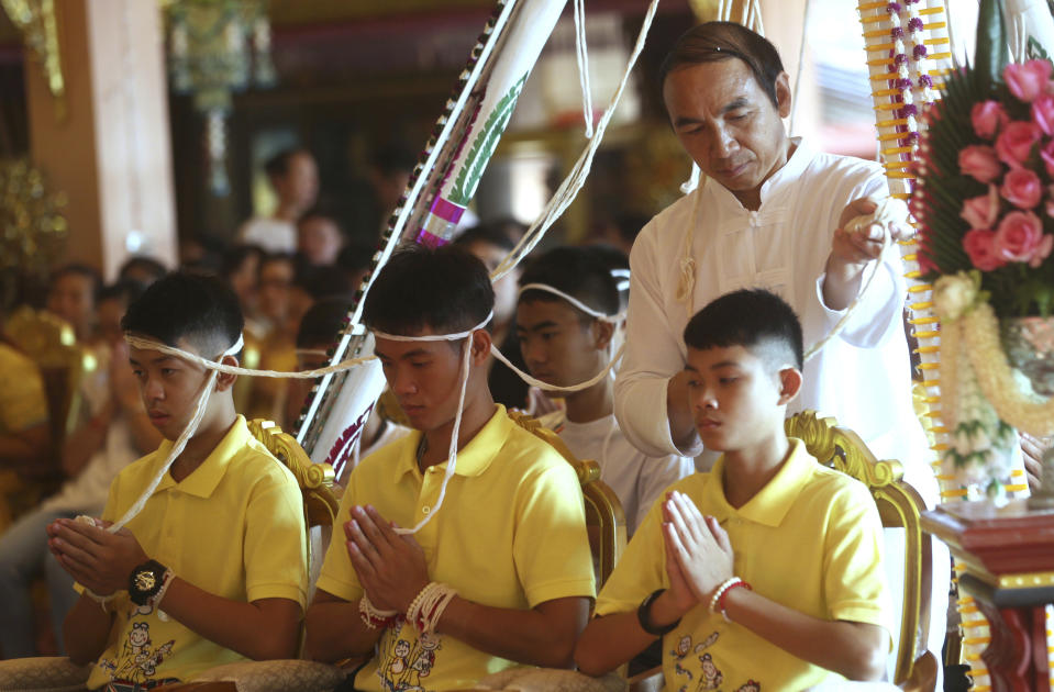 <p>Coach Ekkapol Janthawong, center , and members of rescued soccer team attended a Buddhist ceremony that is believed to extend the lives of its attendees as well as ridding them of dangers and misfortunes in Mae Sai district, Chiang Rai province, northern Thailand, Thursday, July 19, 2018. The 12 boys and their soccer coach rescued from a cave in northern Thailand left the hospital where they had been recuperating and appeared at a news conference Wednesday, saying the ordeal made them stronger and taught them not to live carelessly. (AP Photo/Sakchai Lalit) </p>