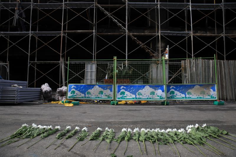 Flowers are placed in front of a damaged residential building following a fire in Kaohsiung, Taiwan