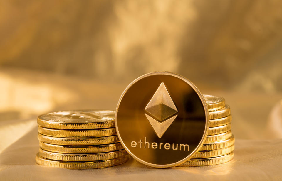 Stack of ether coins or ethereum on gold background to illustrate blockchain and cyber currency