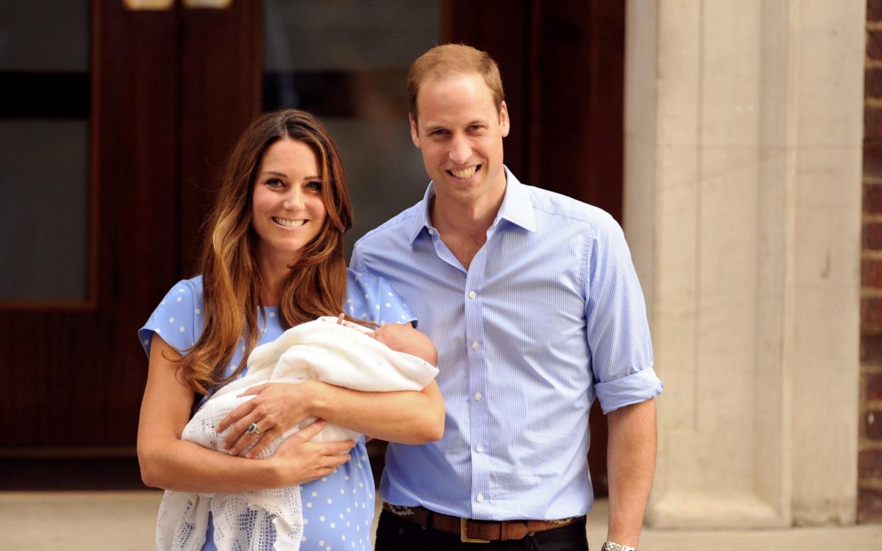 The Duke and Duchess of Cambridge proudly posing with their eldest child Prince George on the steps of the Lindo Wing in July 2013 - PA