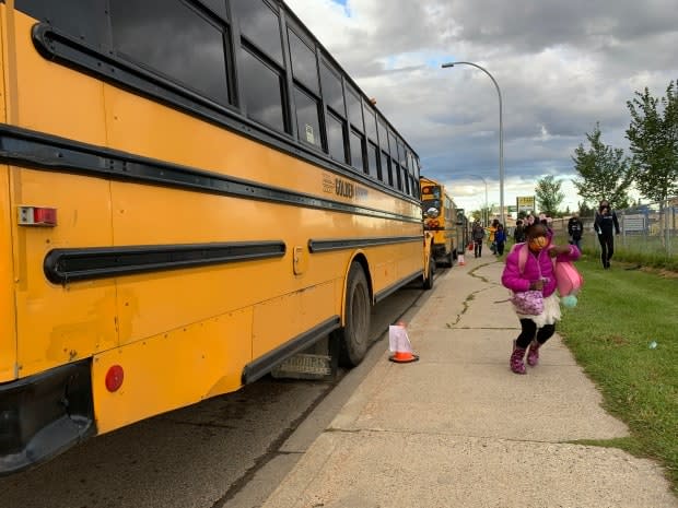 A masked student disembarks her bus and heads off to her first day of school in Edmonton. (Dave Bajer/CBC - image credit)