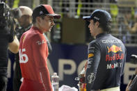 Ferrari driver Charles Leclerc of Monaco, left, who clocked the fastest time, talks with Red Bull driver Sergio Perez of Mexico, second fastest, after the qualifying session at the Singapore Formula One Grand Prix, at the Marina Bay City Circuit in Singapore, Saturday, Oct. 1, 2022. (AP Photo/Vincent Thian)