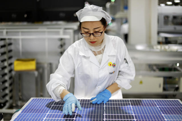 FILE - In this Jan. 5, 2021, file photo, an employee works at a solar panel and solar equipment factory in Jiujiang in central China's Jiangxi Province. The Biden administration’s solar power ambitions are colliding with complaints the global industry depends on Chinese raw materials that might be produced by forced labor. (Chinatopix via AP, File)