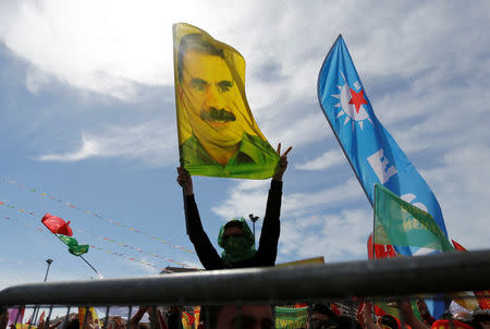 A man holds a flag with a picture of imprisoned Kurdish rebel leader Abdullah Ocalan during a gathering to celebrate Newroz, which marks the arrival of spring and the new year, in Istanbul, Turkey March 21, 2018. REUTERS/Murad Sezer