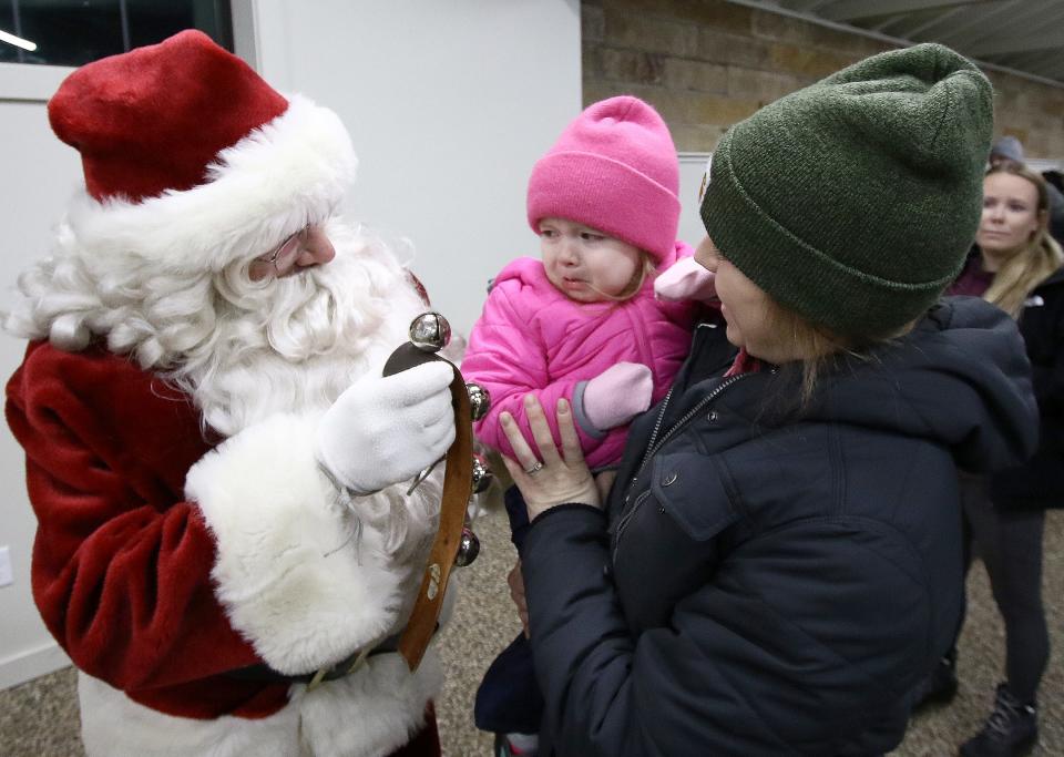 Rylie Cosma, 2, isn't sure she wants to talk to Santa on Saturday, Dec. 3, 2022, as her mom, Vicky Cosma, holds her in the Robertson Lodge during Christmas in the Park at Silver Park.