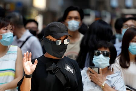 Anti-government office workers wearing masks attend a lunch time protest, after local media reported on an expected ban on face masks under emergency law, at Central, in Hong Kong