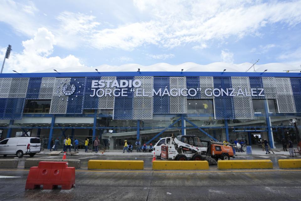 Trabajadores con maquinaria realizan los últimos preparativos para la ceremonia inaugural de los Juegos Centroamericanos y del Caribe en San Salvador, el jueves 22 de junio de 2023 (AP Foto/Arnulfo Franco)