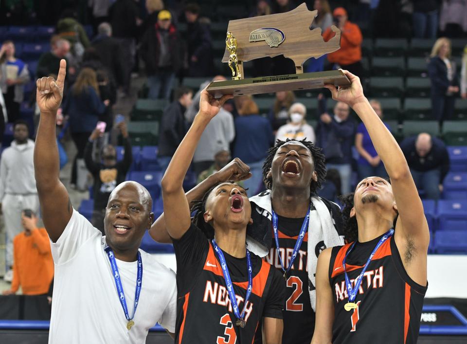 North High School coach Al Pettway and players Tahlan Pettway, Joseph Okla and Ty Tabales hold the Division 1 state championship trophy March 19.