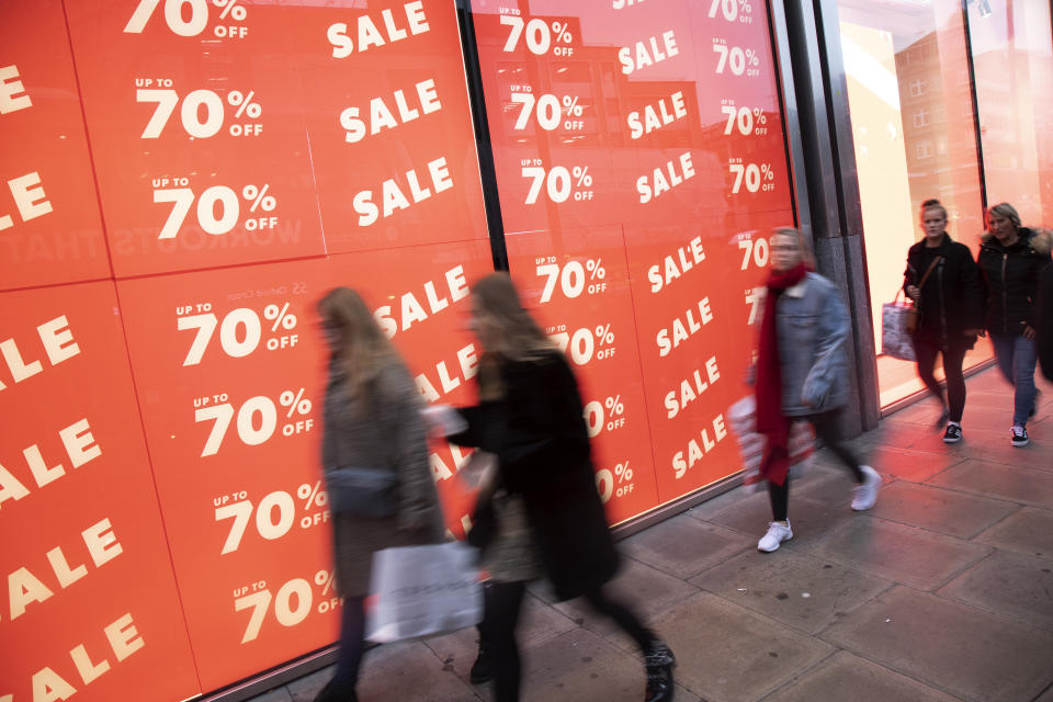 Tough conditions: People out shopping on Oxford Street walk past huge January sale signs in London. Photo: Mike Kemp/In Pictures via Getty Images.