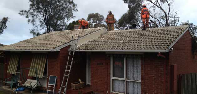 SES volunteers work on a home at Hackham West damaged by a fallen tree. Photo: 7News.