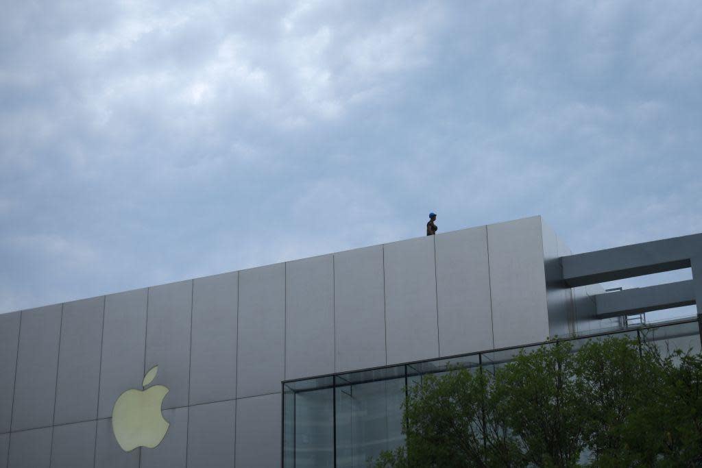 A worker stands on the roof of an Apple store in Beijing, China, on September 1, 2018: AFP/Getty Images