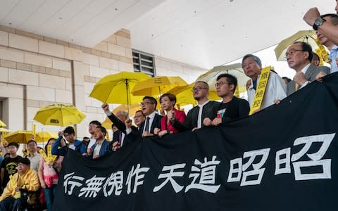 Pro-democracy activists pose for a photograph during a rally outside West Kowloon Court  - Credit:  Anthony Kwan/ Getty Images AsiaPac