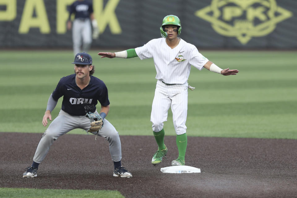 Oregon infielder Rikuu Nishida (56) reacts at second base as Oral Roberts' Mac McCroskey (12) watches the play at first during the seventh inning of an NCAA college baseball tournament super regional game Friday, June 9, 2023, in Eugene, Ore. (AP Photo/Amanda Loman)