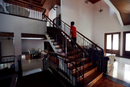 A house guard walks at an empty rental house at Kemang district in Jakarta, Indonesia, June 23, 2016. REUTERS/Beawiharta