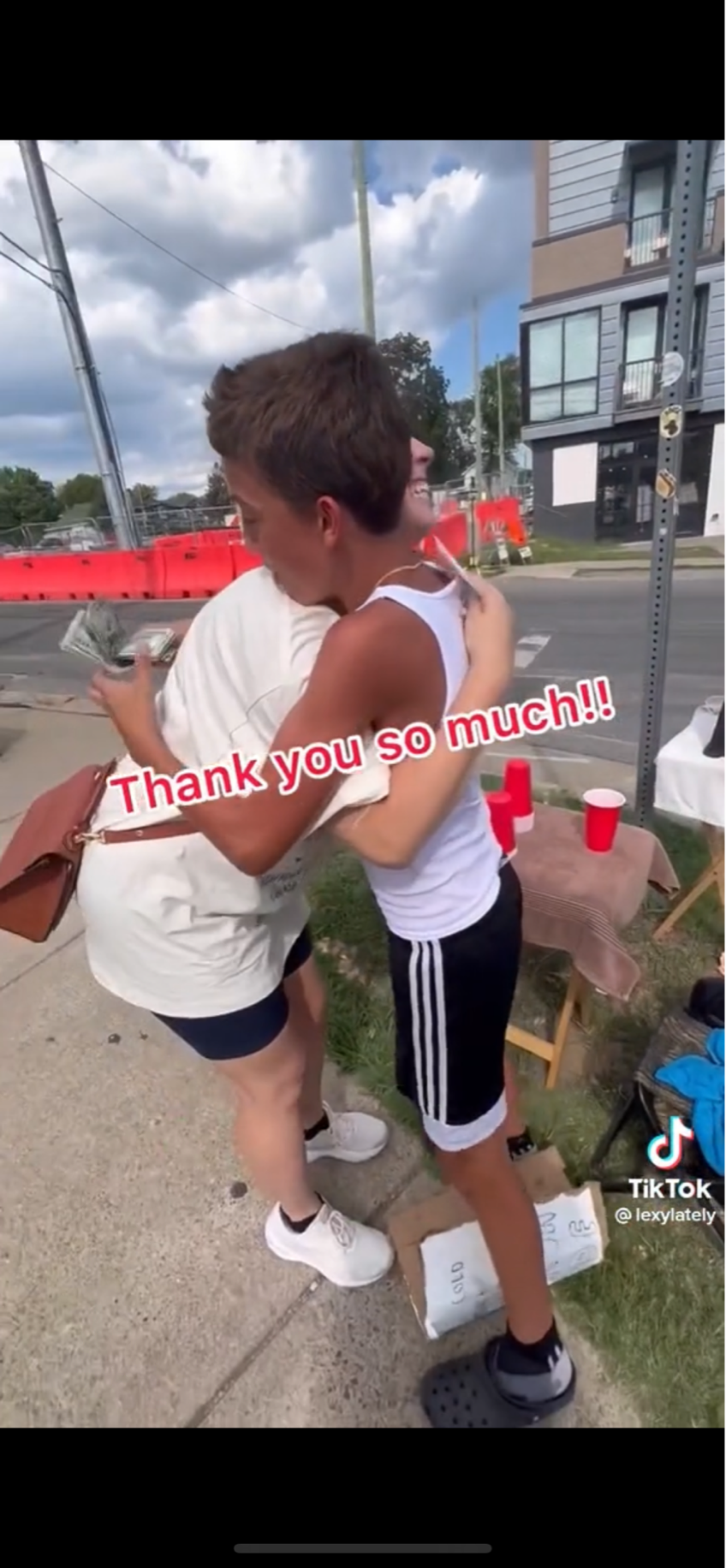A screen grab of a TikTok video where Nashville "serial tipper" Lexy Burke bought a $3 glass of lemonade from 11-year-old Niko for $1,100 on July 27, 2022, along 12 South. Niko hugs Lexy while clutching 11 $100 bills.