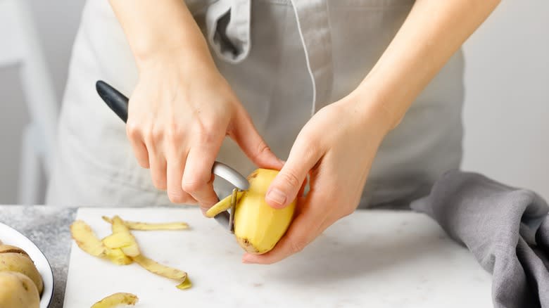 Someone peeling a potato