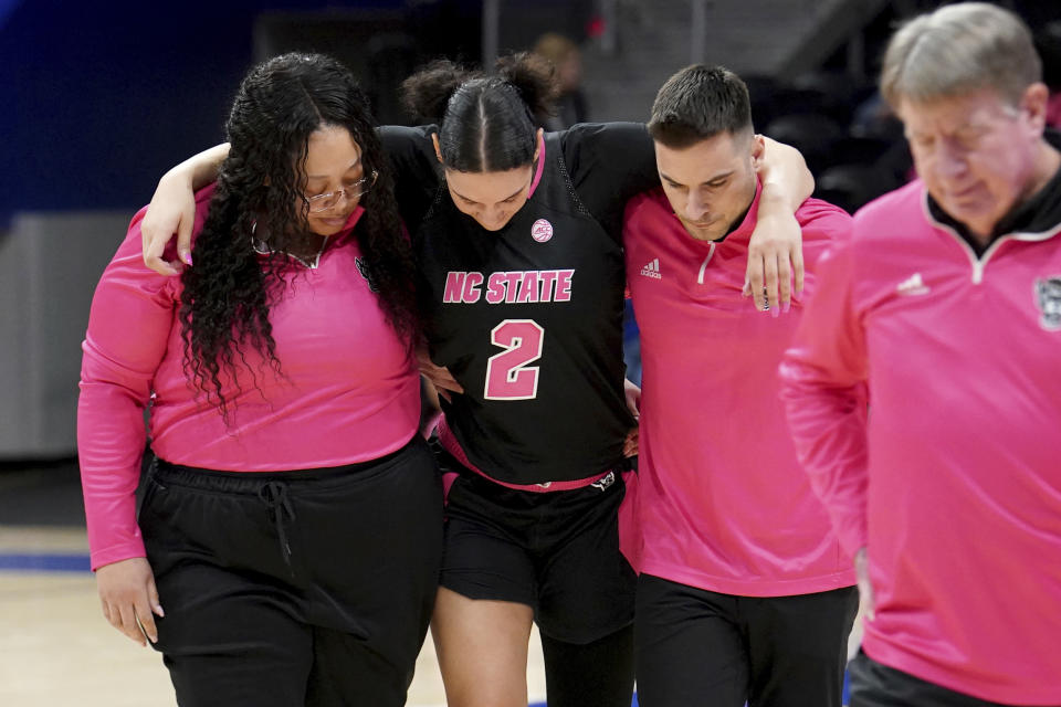 North Carolina State forward Mimi Collins (2) is helped to the bench after getting injured during the second half of an NCAA college basketball game against Pittsburgh, Sunday, Feb. 11, 2024, in Pittsburgh. (AP Photo/Matt Freed)