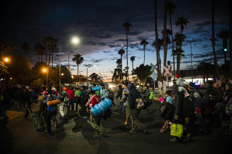 Migrantes centroamericanos, que integran una caravana multitudinaria que marcha hacia Estados Unidos, caminan por una calle de la ciudad mexicana de Mexicali cerca de la frontera con EEUU, el 19 de noviembre de 2018. (AFP | PEDRO PARDO)