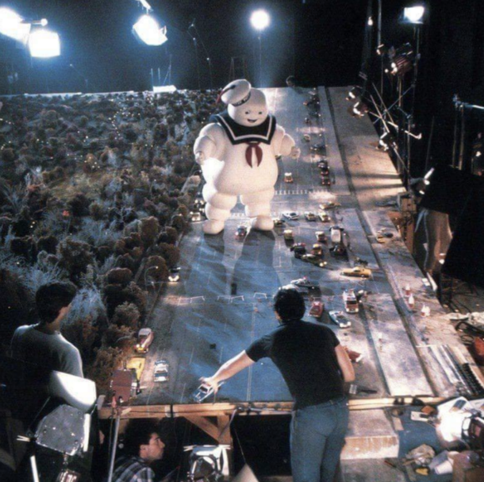 large pillsbury man on a manmade street with fake cars