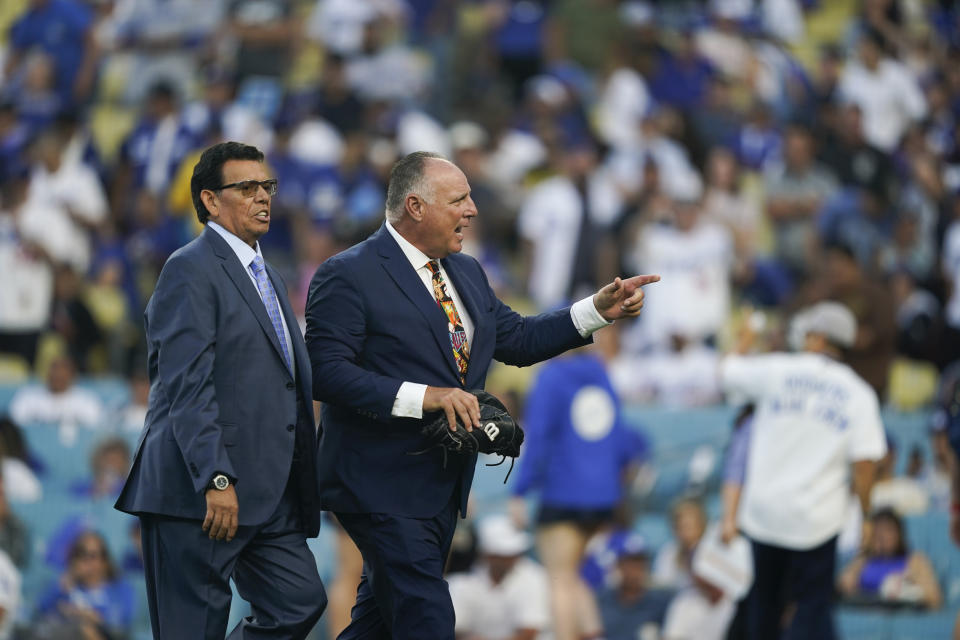 Former Los Angeles Dodgers pitcher Fernando Valenzuela, left, walks with former teammate Mike Scioscia after throwing out the first pitch before the baseball game between the Dodgers and the Colorado Rockies, Friday, Aug. 11, 2023, in Los Angeles. (AP Photo/Ryan Sun)