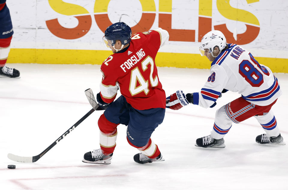 New York Rangers right wing Patrick Kane (88) hooks Florida Panthers defenseman Gustav Forsling (42) during the first period of an NHL hockey game Saturday, March 25, 2023, in Sunrise, Fla. Kane was called for a hooking penalty on the play. (AP Photo/Rhona Wise)