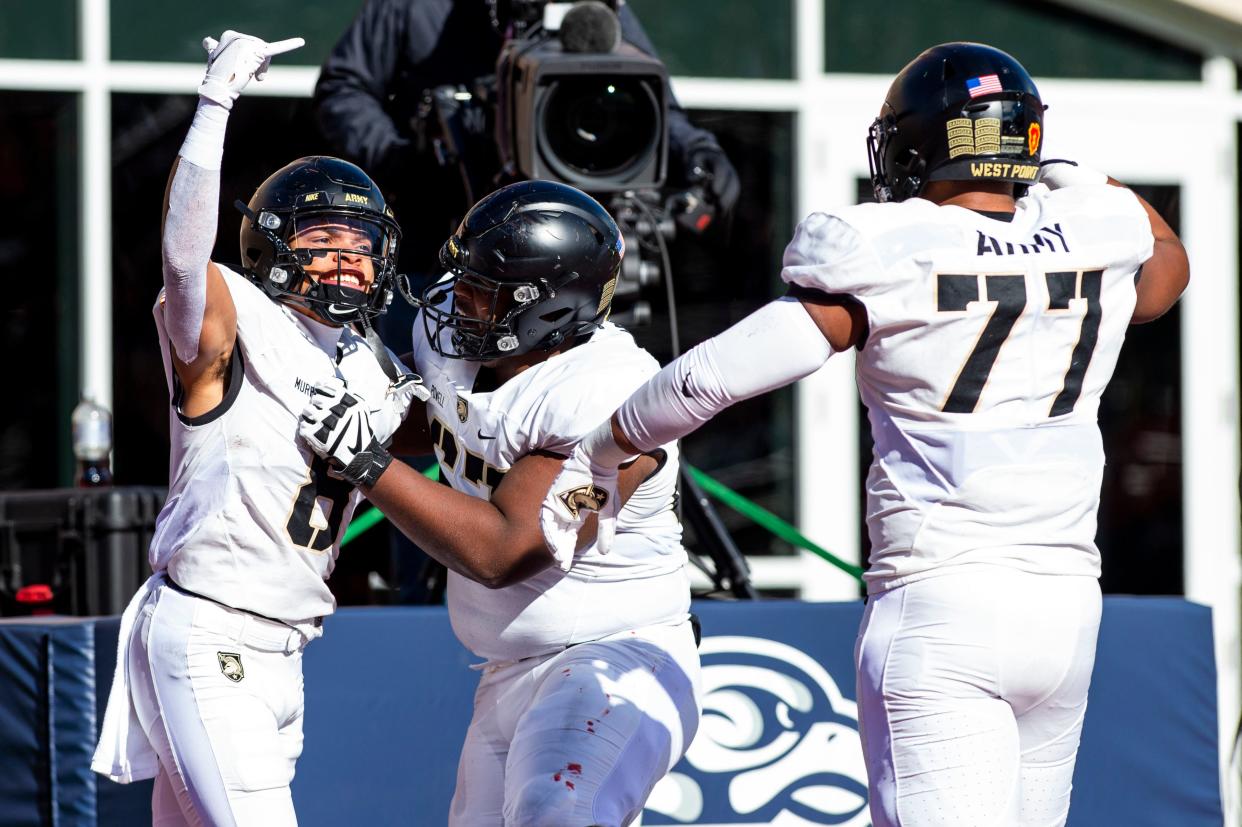 Army running back Braheam Murphy (8) celebrates with teammates after a touchdown against Liberty on Saturday at Williams Stadium in Lynchburg, Va. (Kendall Warner/The News & Advance via AP)