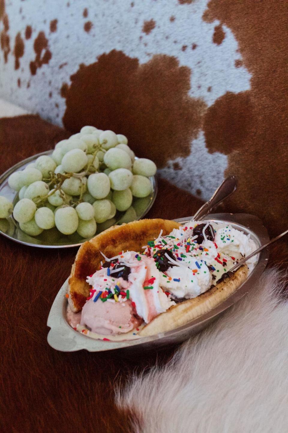 A banana split and a platter of frozen grapes