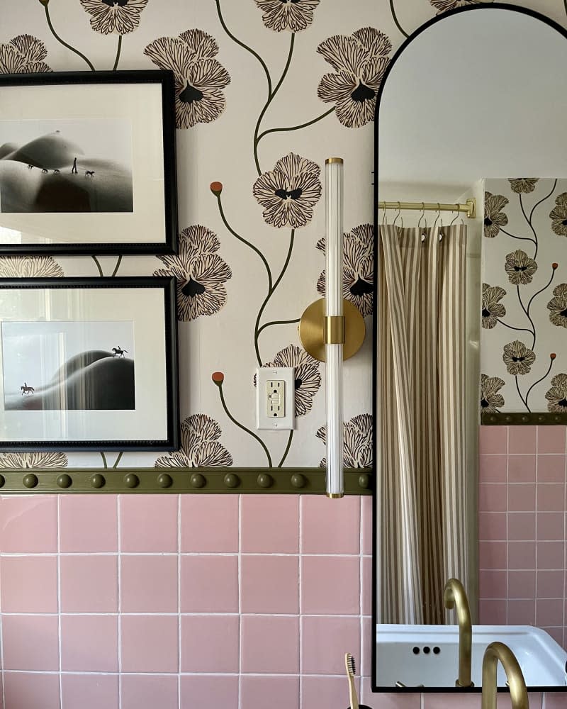 bathroom with pink tile, arched mirror, botanical wallpaper, and gold hardware/accents after remodel