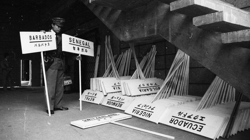 A Japanese policeman checks the signs to be used during the opening parade at the Olympic Games in Tokyo, 1964. - Douglas Miller/Hulton Archive/Getty Images