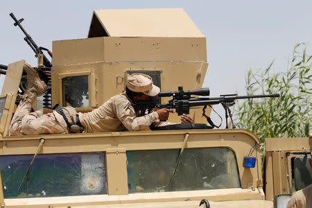 An Iraqi security forces sniper looks through the scope of his rifle near Falluja, Iraq, May 25, 2016. REUTERS/Thaier Al-Sudani