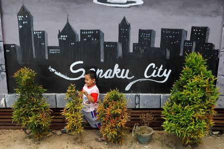 A boy plays outside a coffee shop at Sepaku district in North Penajam Paser regency, East Kalimantan province