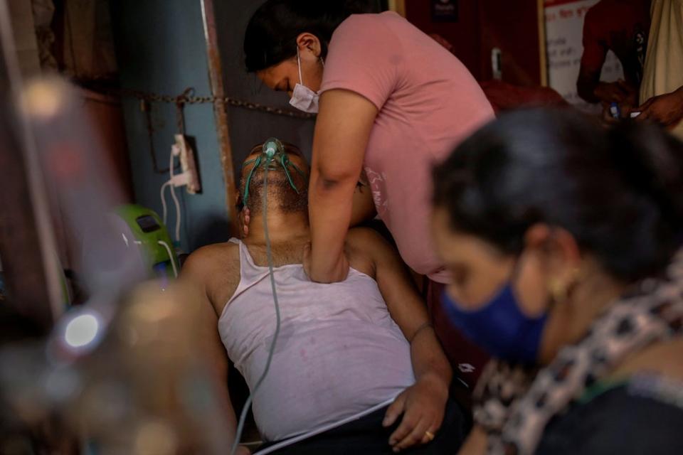 Manisha Bashu presses the chest of her father, who was having difficulty breathing, after he fell unconscious while receiving oxygen support at a Gurdwara (Sikh temple) in Ghaziabad on 30 April 2021 (Reuters/Adnan Abidi)