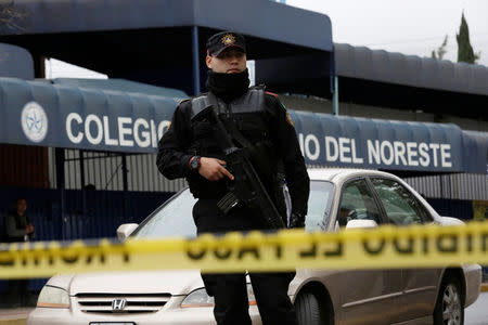 A police officer stands outside the Colegio Americano del Noreste after a student opened fire at the American school in Monterrey, Mexico January 18, 2017. REUTERS/Daniel Becerril