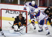 Edmonton Oilers forward Evander Kane (91) tries to score on Calgary Flames goalie Jacob Markstrom (25) as forward Warren Foegele (37) watches during the third period of an NHL hockey game Saturday, April 6, 2024, in Calgary, Alberta. (Jeff McIntosh/The Canadian Press via AP)