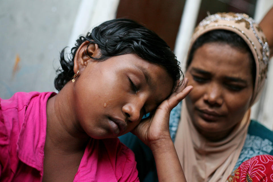 In this Oct. 19, 2013 photo, young ethnic Rohingya asylum seeker Senwara Begum, left, cries at a temporary shelter in Medan, North Sumatra, Indonesia after making a phone call to her family in Myanmar. After her tiny Muslim village in Myanmar's northwest Rakhine had been destroyed in a fire set by an angry Buddhist mob, she and her brother became separated from their family. (AP Photo/Binsar Bakkara)