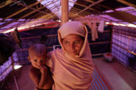 Gol Bahar, a 45-year-old Rohingya refugee poses for a picture with her grandchild at her shelter in the camp for widows and orphans inside the Balukhali camp near Cox's Bazar, Bangladesh, December 5, 2017. Gol Bahar, from Labadug village in Buthidaung township, said her husband, who was collecting wood as the area came under attack from Myanmar military, is among many missing Rohingya men from their village. Gol Bahar now lives with her two daughters and more than 230 others at the camp for Rohingya widows and orphans. Two of her other, married daughters, also found shelter with their families at Balukhali camp and she sometimes takes care of their children. REUTERS/Damir Sagolj