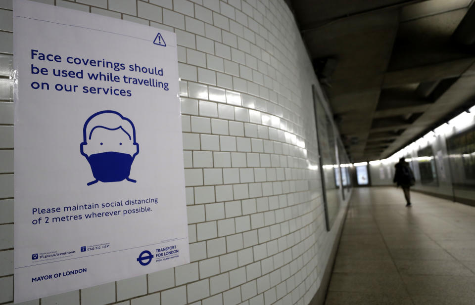 A sign advises travellers to wear face coverings at Westminster Station in London, Friday, June 5, 2020.  It will become compulsory to wear face coverings whilst using public transport in England from Monday June 15. (AP Photo/Kirsty Wigglesworth)