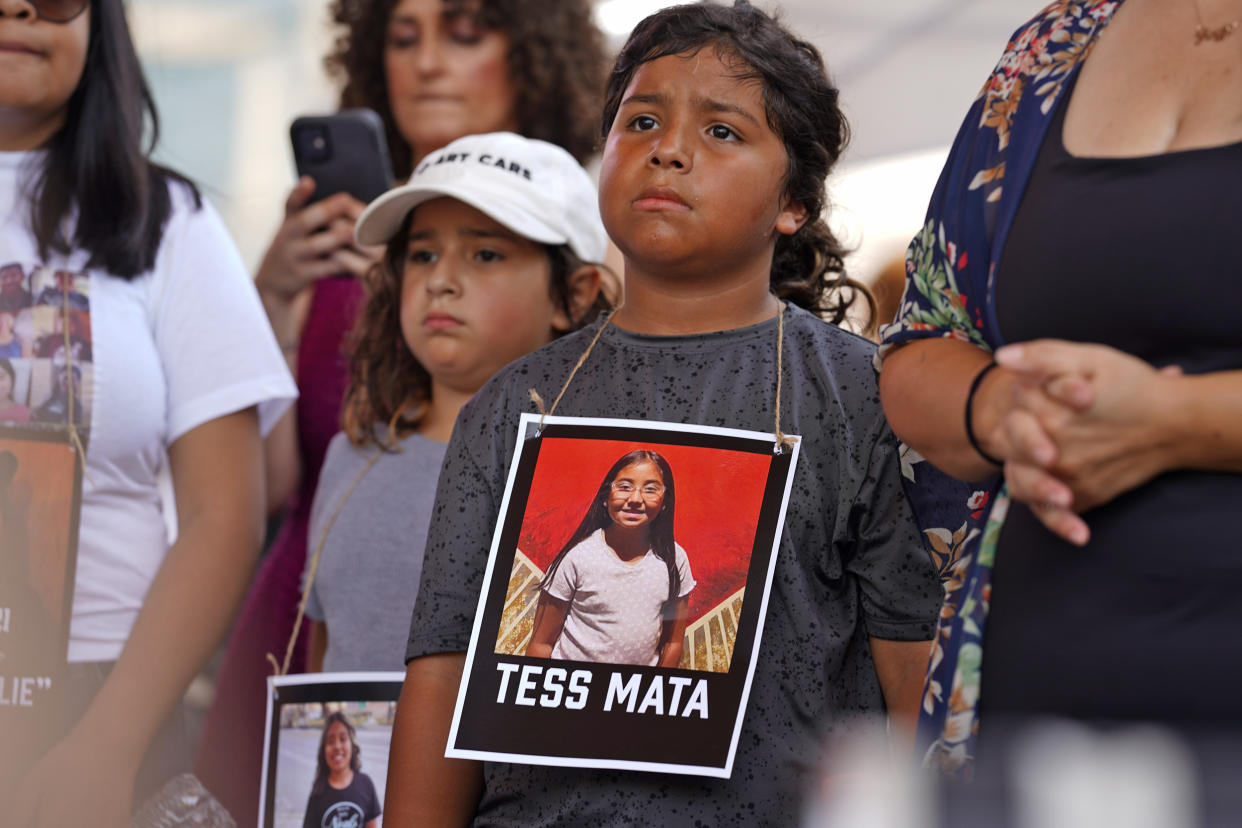 A young protester wears an image of Tess Mata, who was killed in the Uvalde school shooting, outside the NRA meeting.  (Allison Dinner for NBC News)