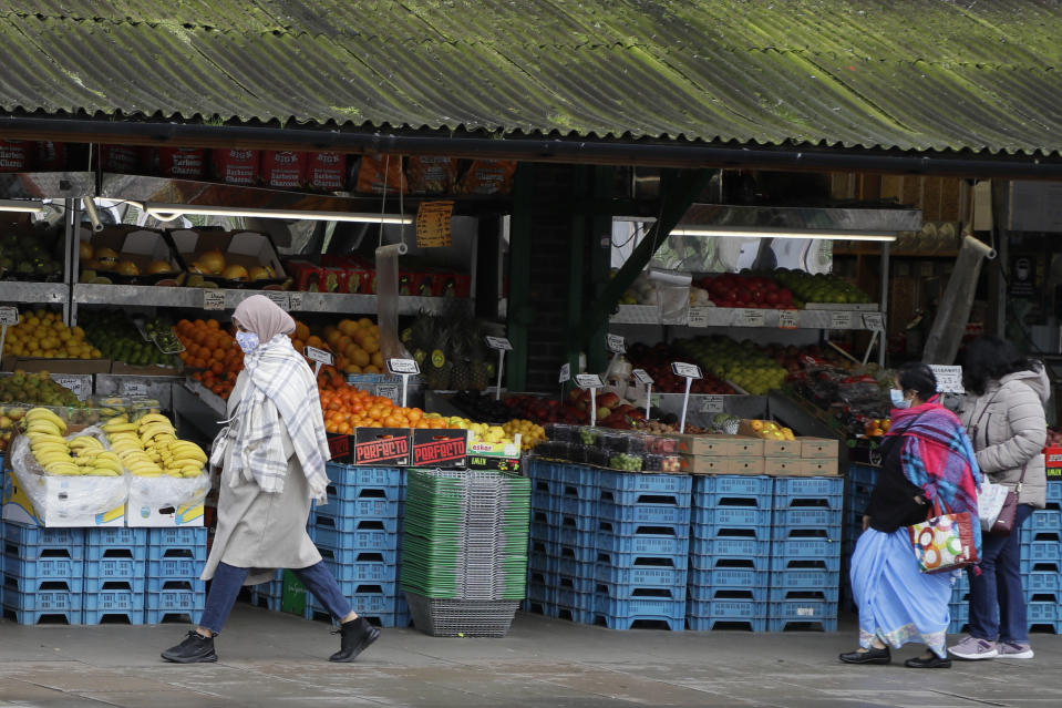 People wear protective face coverings as they shop in West Ealing in London, Thursday, Feb. 25, 2021. It has been announced that further testing of residents in the London Borough of Ealing will be carried out after additional cases of the coronavirus variant first identified in South Africa were detected. (AP Photo/Kirsty Wigglesworth)